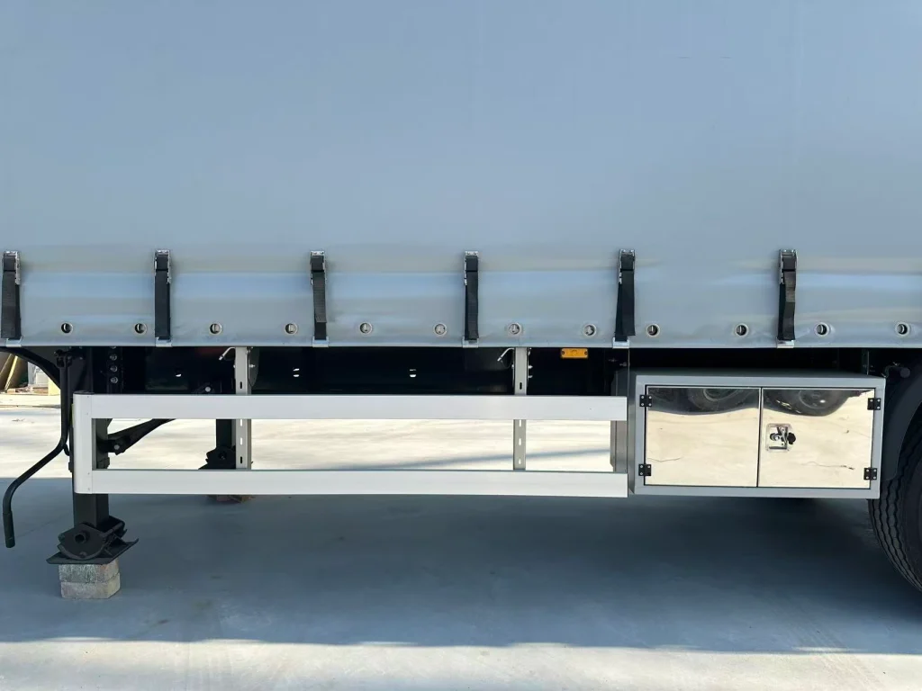 Grey side curtain with lower buckle straps above the side guard and toolbox