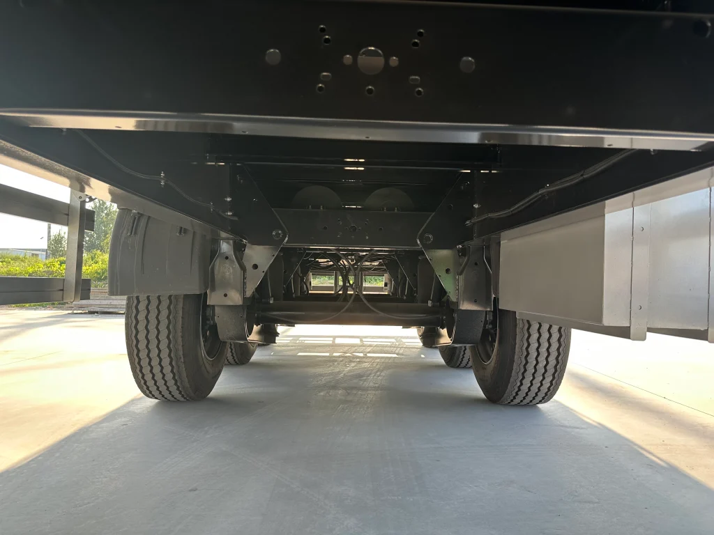 Chassis beams and crossmembers beneath the curtain side trailer cargo floor